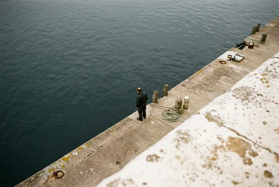 Dark water meeting a pale concrete harbour edge